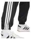 Adidas Essentials 3-Stripes Fleece Loose-Fit Joggers in grey, cozy casual pants with iconic side stripes, made from recycled cotton and polyester blend