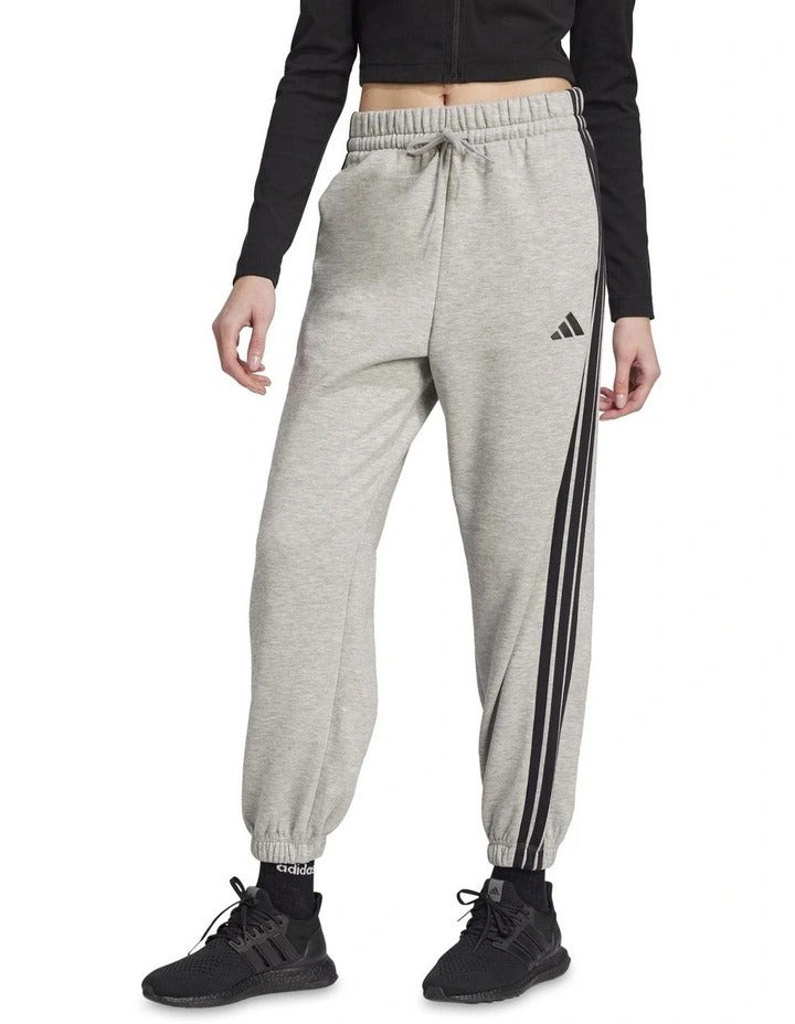 Adidas Essentials 3-Stripes Fleece Loose-Fit Joggers in grey, cozy casual pants with iconic side stripes, made from recycled cotton and polyester blend