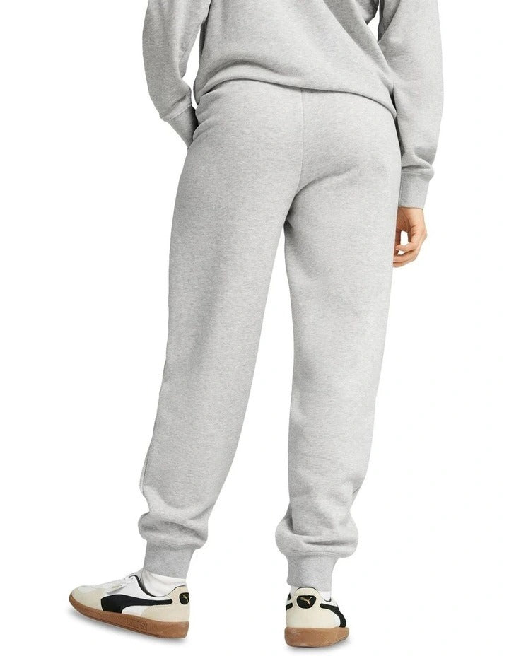 Person wearing gray Puma sweatpants on a white background