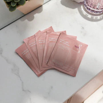 Lavvish Bio Collagen Face Mask set of 5 in elegant pink packaging displayed on marble surface with skincare accessories