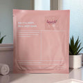 Lavvish Bio Collagen Face Mask in pink packaging displayed on vanity with soft natural lighting and skincare accessories